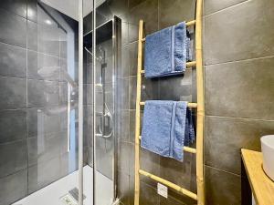 a bathroom with a shower with blue towels at COCON HYPER CENTRE-VILLE TOUT CONFORT (8) in Ajaccio +15 photos