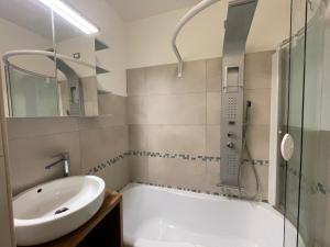 a bathroom with a tub and a sink and a shower at Alpèa in Lavarone
