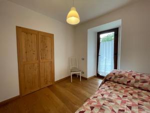 a bedroom with a bed and a door and a window at Alpèa in Lavarone