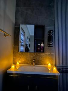 a bathroom with a sink with candles and a mirror at Lukholo guest house siyabuswa in Siyabuswa +15 photos
