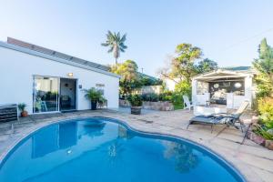 a swimming pool in the backyard of a house at Villa Palmera in Mossel Bay