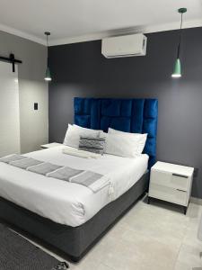 a large bed with a blue headboard in a bedroom at Lukholo guest house siyabuswa in Siyabuswa