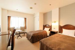 a hotel room with two beds and a desk at Hirosaki Park Hotel in Hirosaki +71 photos