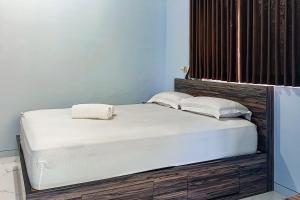 a bed with two pillows on it in a room at Dprof Exclusive Guesthouse Semarang RedPartner in Jatingaleh