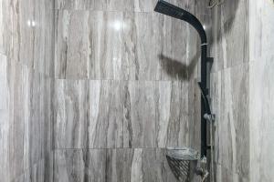 a shower in a bathroom with a wooden wall at Dprof Exclusive Guesthouse Semarang RedPartner in Jatingaleh +35 photos