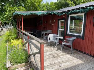 a red cabin with chairs and a table on a deck at Kosta Bed in Kosta +9 photos