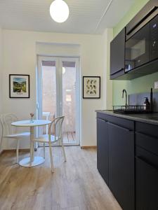 a kitchen with a table and a table and chairs at Studio cocooning à 5km du centre de Strasbourg in Schiltigheim