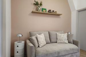 a gray couch in a living room with a lamp at Studio cocooning à 5km du centre de Strasbourg in Schiltigheim
