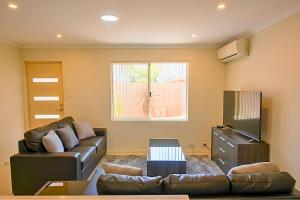 a living room with a couch and a television at Midland Haven - Midland WA in Midland Junction