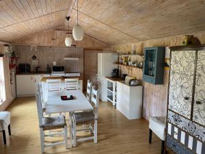 a kitchen and dining room with a white table and chairs at Kosta Bed in Kosta