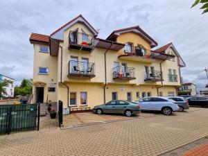 a large building with cars parked in a parking lot at Tawerna Michałowscy in Mielno