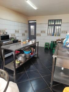 a kitchen with a table with pots and pans at J & J Olosho Hotel in Kiserian