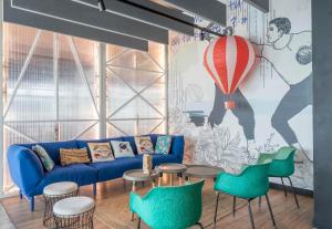 a living room with a blue couch and green chairs at B&B HOME La Ciotat in La Ciotat