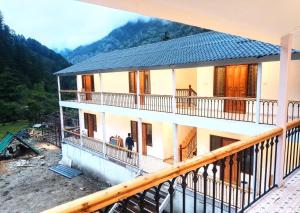 a man standing on the balcony of a house at Namami Harsil in Harsil +13 photos