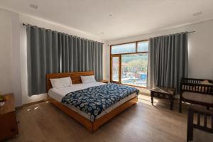 a bedroom with a bed and a large window at Namami Harsil in Harsil