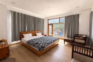 a bedroom with a bed and a large window at Namami Harsil in Harsil
