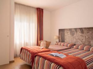 a hotel room with two beds with books on them at Aparthotel Ona Aucanada in Port d'Alcudia +38 photos
