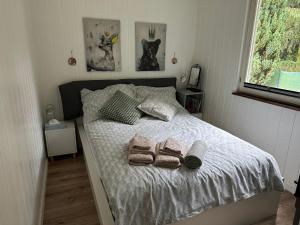 a bedroom with a bed with towels on it at Domek Pod Świerkami in Wólka
