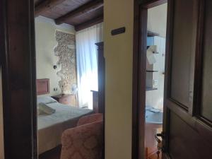 a bedroom with a bed and a window and a chair at Affittacamere Isidoro in Zaccanopoli