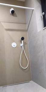 a shower with a hose attached to a wall at Studio E9 in Žilina