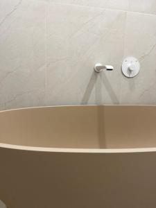 a bath tub in a bathroom with a white tile wall at Studio E9 in Žilina