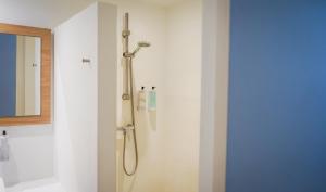 a shower in a bathroom next to a mirror at Xubec - Albergue Juvenil in Ciutadella +24 photos