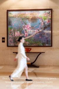 a man walking past a painting in a museum at Shangri-La Chengdu in Chengdu