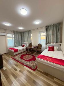 a bedroom with two beds and a table in it at Khatanmandal in Dalandzadgad
