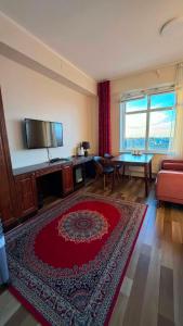 a living room with a couch and a red rug at Khatanmandal in Dalandzadgad +18 photos