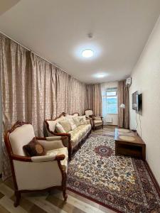 a living room with a couch and chairs in it at Khatanmandal in Dalandzadgad