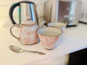 two cups and spoons are sitting on a counter at Garden Studio - Tranquil Forest Retreat in Currumbin Valley