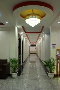 a hallway in a building with a chandelier and plants at Hotel sphatic in Chitrakoot