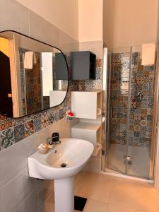 a bathroom with a sink and a mirror and a shower at Magazzino Mediterraneo in Praia a Mare