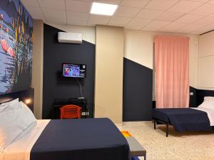 a room with two beds and a tv on a wall at Magazzino Mediterraneo in Praia a Mare