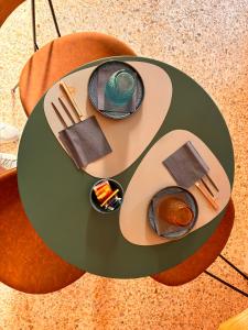 a green table with plates and utensils on it at Magazzino Mediterraneo in Praia a Mare