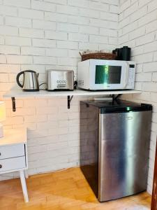 a microwave sitting on top of a counter with a refrigerator at Garden Studio - Tranquil Forest Retreat in Currumbin Valley
