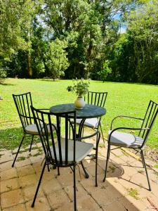 two chairs and a table with a vase on it at Garden Studio - Tranquil Forest Retreat in Currumbin Valley