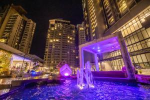a fountain in the middle of a city at night at Premium Suites D'lement Genting Highlands by BYON in Genting Highlands +153 photos
