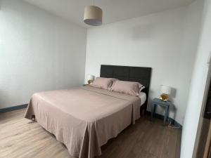 a bedroom with a bed and a table with a lamp at G Opératif in Ornans
