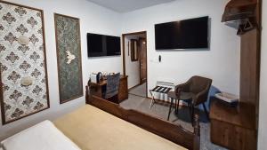 a bedroom with a bed and a tv and a chair at Cieszyński by Imperis Hotels in Cieszyn