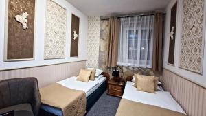 a room with two beds and a chair and a window at Cieszyński by Imperis Hotels in Cieszyn +102 photos