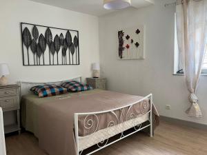 a bedroom with a bed and some pictures on the wall at G Opératif in Ornans