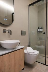 a bathroom with a sink and a toilet and a shower at Essence 55 Living in Rhodes Town +6 photos