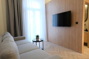 a living room with a couch and a television on a wall at Essence 55 Living in Rhodes Town