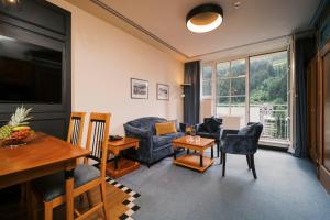 a living room with a couch and a table at MONDI Hotel Bellevue Gastein in Bad Gastein