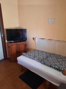 a bedroom with a bed with a butterfly on the wall at Bogi vendégház in Mezőkövesd