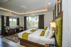 a bedroom with a bed and a desk and a window at Lumino Winter Castle, Munnar in Pooppara +42 photos