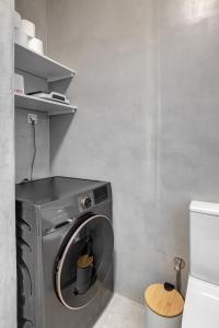 a washing machine in a bathroom next to a toilet at Garden Residence in Ermoupoli