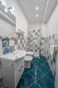 a bathroom with a white sink and a toilet at Antico Palazzo del Corso by Home Dardano in Mirto Crosia +65 photos