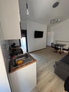 a kitchen and a living room with a table at Apartamento Turístico La Miranda in Elche de la Sierra